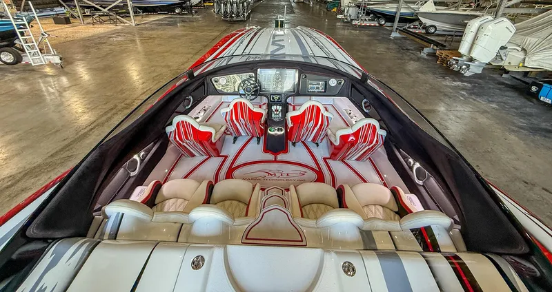 Slide: The Image of Interior of a 2019 MTI 48 boat with red and white seating in a warehouse. - 46