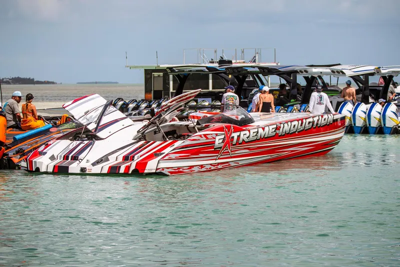 Slide: The Image of High-performance MTI 48 speedboat docked, featuring bold red and white graphics, 2019 model. - 5