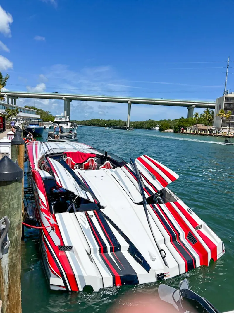 Slide: The Image of Colorful 2019 MTI 48 speedboat docked by a scenic waterway under a clear blue sky. - 6