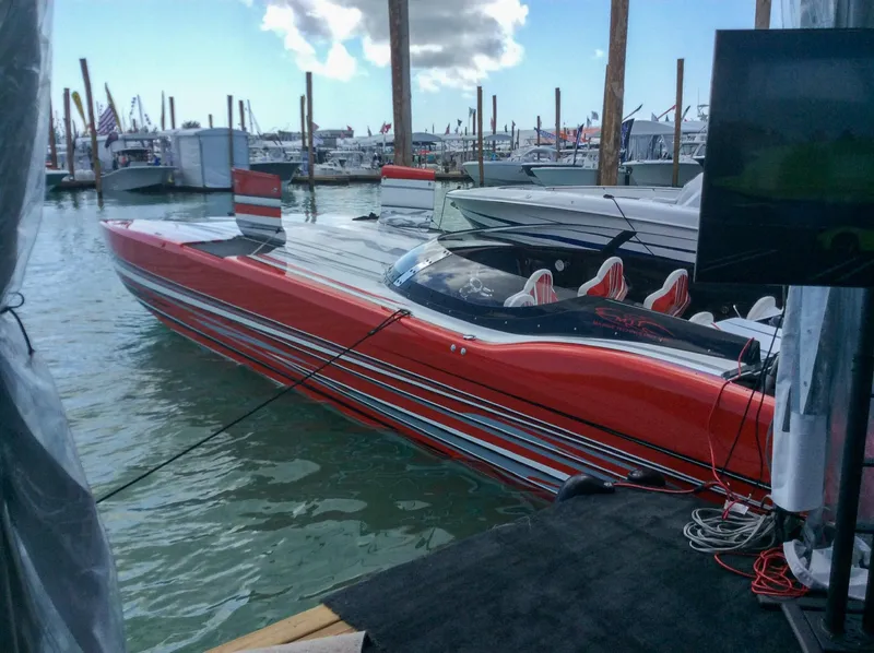 Slide: The Image of Red MTI 48 speedboat docked at marina, 2019 model, with sleek design and striped detailing. - 8