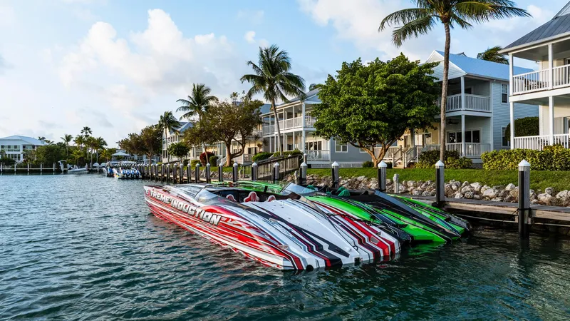 Slide: The Image of 2019 MTI 48 speedboats docked by waterfront homes with palm trees. - 9