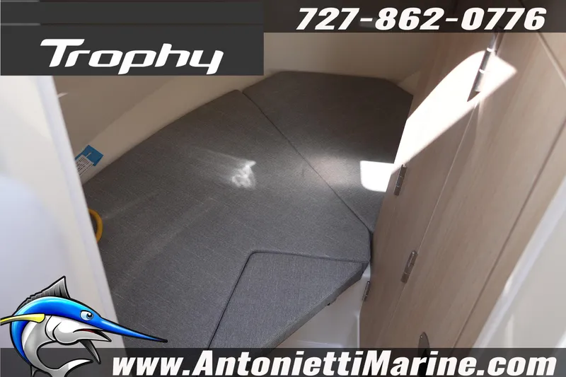 Slide: The Image of 2026 Bayliner Trophy T25 Pilothouse cabin interior with gray cushions, showcased by Antonietti Marine. - 36