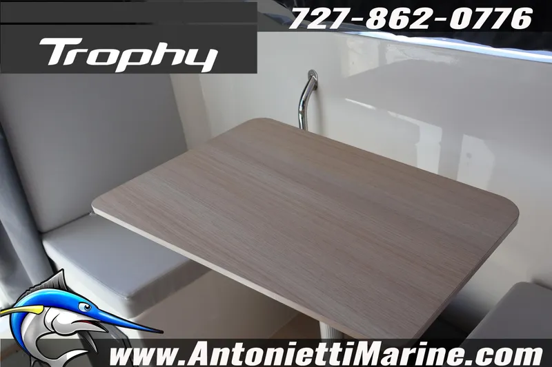 Slide: The Image of 2026 Bayliner Trophy T25 Pilothouse interior with seating and table, Antonietti Marine branding. - 40