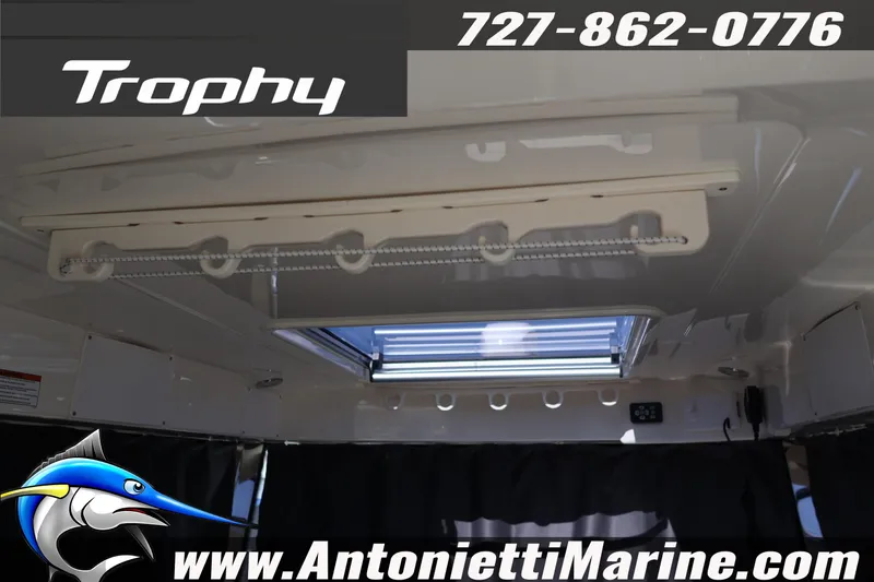 Slide: The Image of 2026 Bayliner Trophy T25 Pilothouse interior with skylight and contact information. - 42