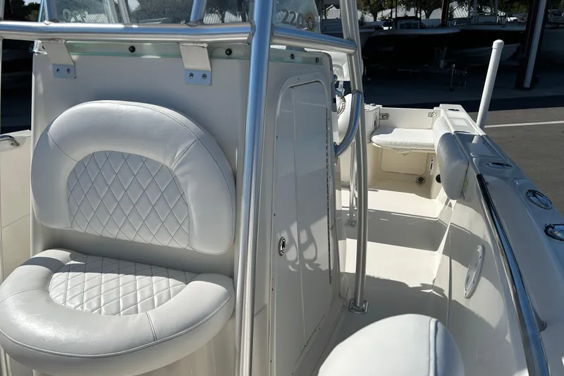 Slide: The Image of 2015 Sailfish 220 CC boat interior with white cushioned seating and sleek design. - 10