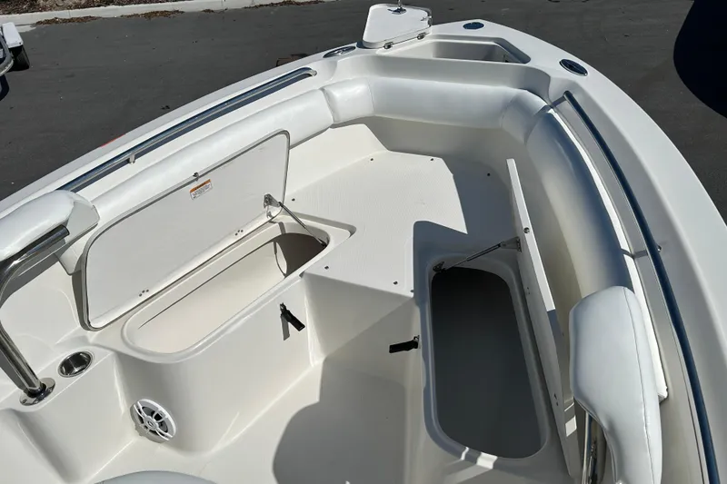 Slide: The Image of 2015 Sailfish 220 CC boat interior with open storage compartments and cushioned seating. - 14