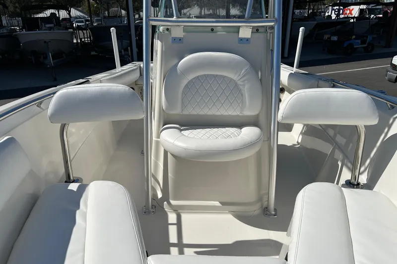 Slide: The Image of 2015 Sailfish 220 CC boat interior with white cushioned seating and console. - 9