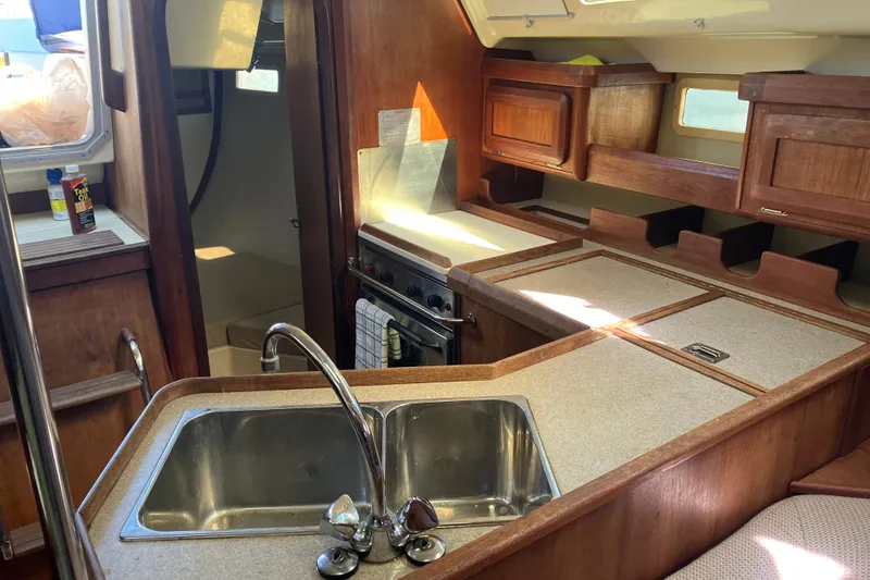 Slide: The Image of Interior of 1995 Hunter Legend 35.5 sailboat kitchen with sink and wooden cabinetry. - 3