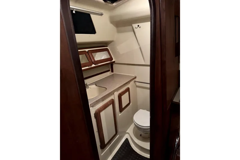 Slide: The Image of 1995 Hunter Legend 35.5 yacht bathroom with sink, toilet, and wooden cabinets. - 7