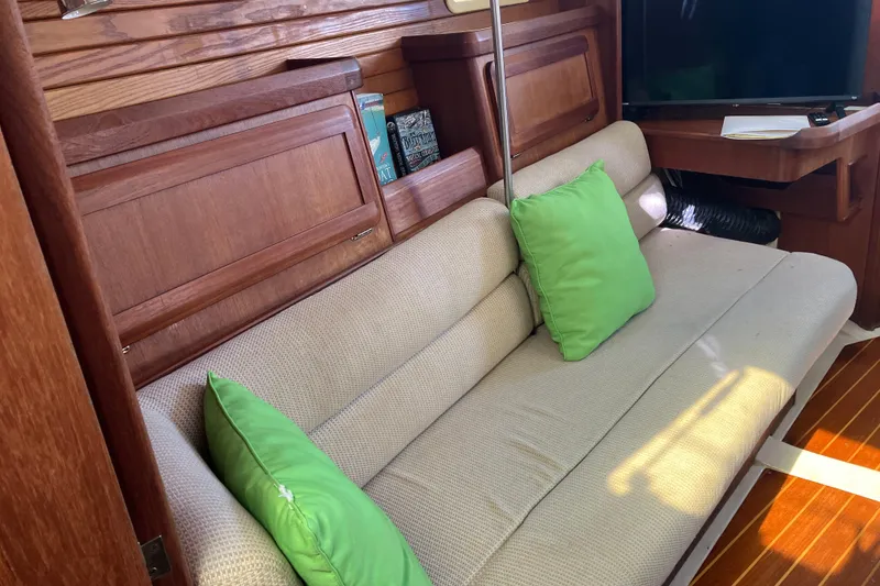 Slide: The Image of Cozy interior of 1995 Hunter Legend 35.5 sailboat with green cushions and wooden accents. - 8