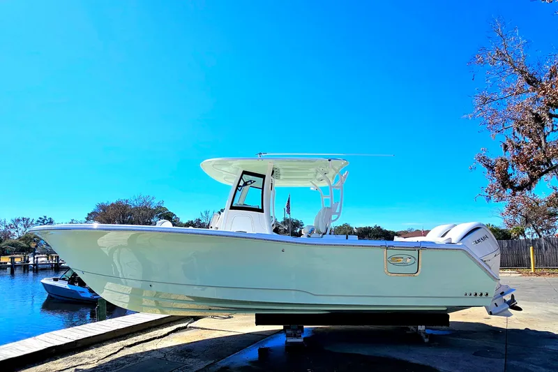 Slide: The Image of 2026 Sea Hunt Ultra 285 SE boat docked under clear blue sky. - 2