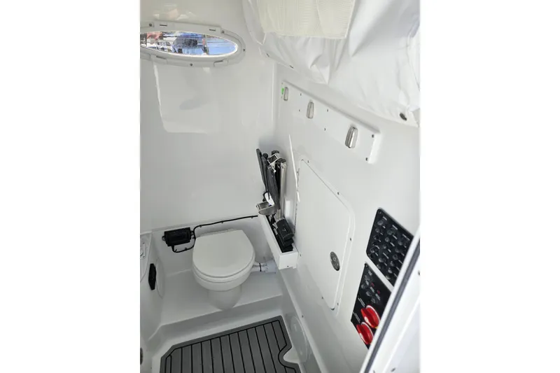 Slide: The Image of Interior of 2026 Sea Hunt Ultra 285 SE boat, featuring a compact marine toilet. - 31