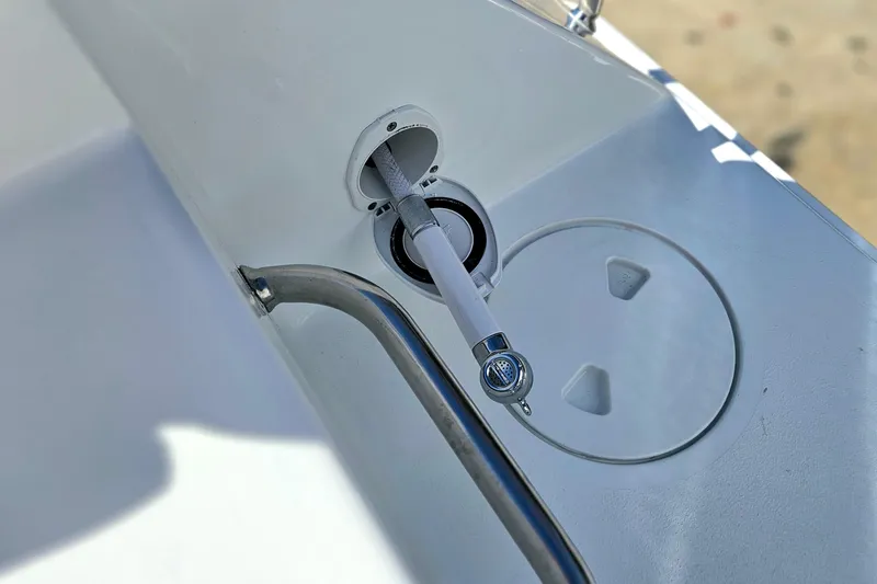 Slide: The Image of 2026 Sea Hunt Ultra 285 SE boat deck with hose and storage compartment. - 6