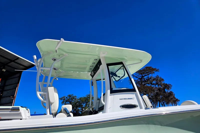 Slide: The Image of 2026 Sea Hunt Ultra 285 SE boat with T-top against clear blue sky. - 8