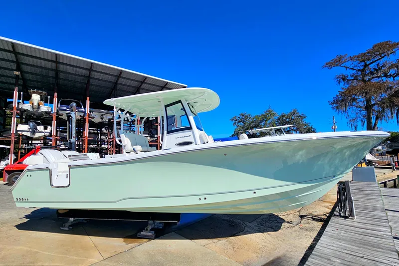 Slide: The Image of 2026 Sea Hunt Ultra 285 SE boat on display at a marina under clear blue skies. - 9