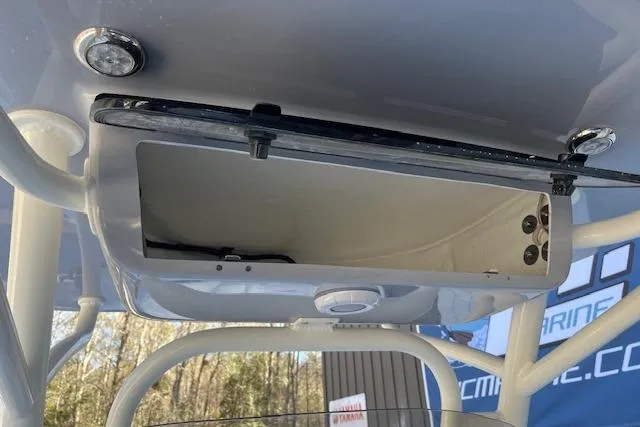 Slide: The Image of 2026 Key West 219 FS boat console with open storage compartment and mounted lights. - 12