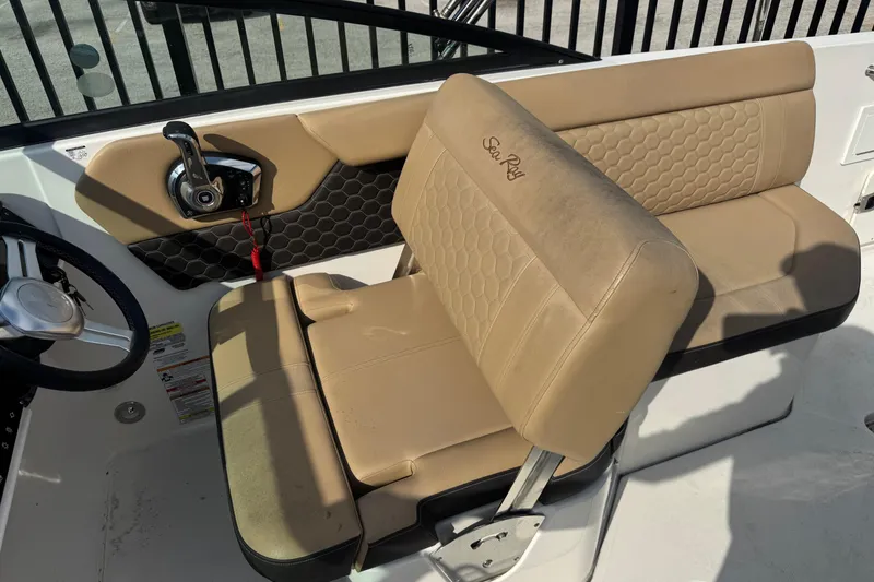 Slide: The Image of 2023 Sea Ray SDX 250 Outboard boat interior with tan seating and steering controls. - 13