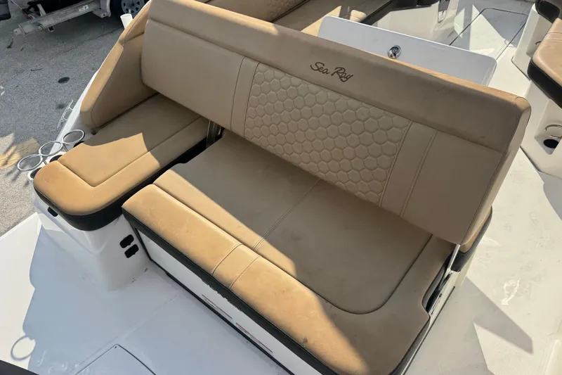 Slide: The Image of 2023 Sea Ray SDX 250 Outboard boat seating with beige upholstery and cup holders. - 15