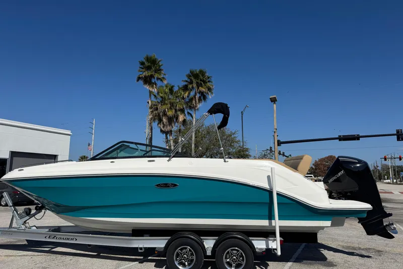 Slide: The Image of 2023 Sea Ray SDX 250 Outboard boat on trailer, parked under clear blue sky. - 3