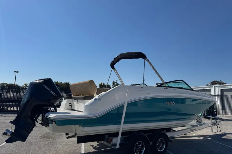 Slide: The Image of 2023 Sea Ray SDX 250 Outboard boat on trailer under clear blue sky. - 6