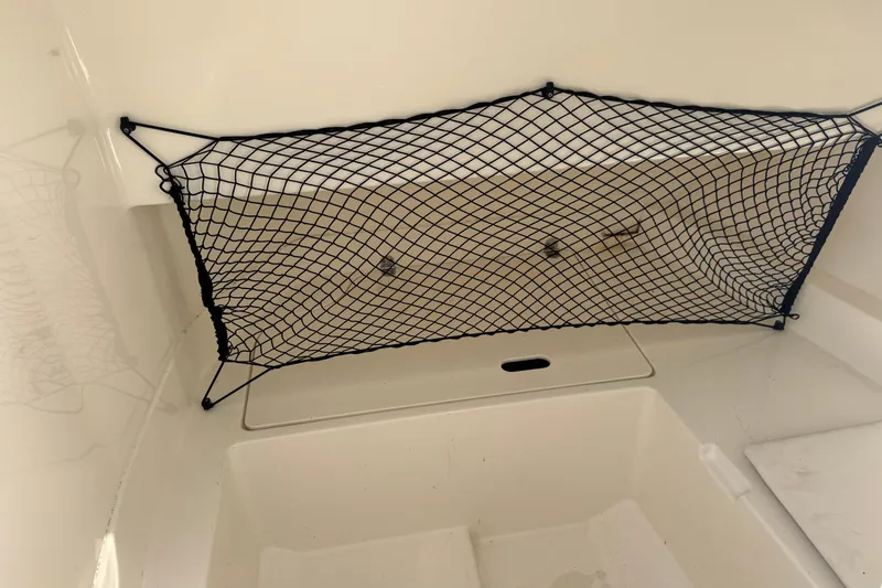 Slide: The Image of Storage compartment with netting in 2023 Sea Ray SDX 250 Outboard boat. - 9