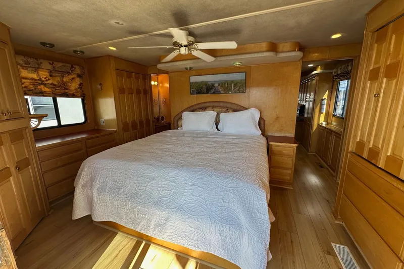 Slide: The Image of Cozy bedroom in 2000 Sumerset 16x73 houseboat with wood paneling and ceiling fan. - 10