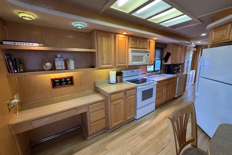 Slide: The Image of Spacious kitchen in 2000 Sumerset 16x73 houseboat with wooden cabinets and modern appliances. - 4