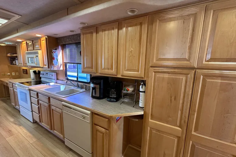 Slide: The Image of Kitchen interior of 2000 Sumerset 16x73 houseboat with wooden cabinets and modern appliances. - 5