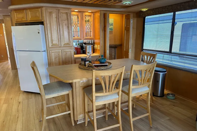 Slide: The Image of Kitchen interior of 2000 Sumerset 16x73 houseboat with wooden cabinets and dining area. - 6