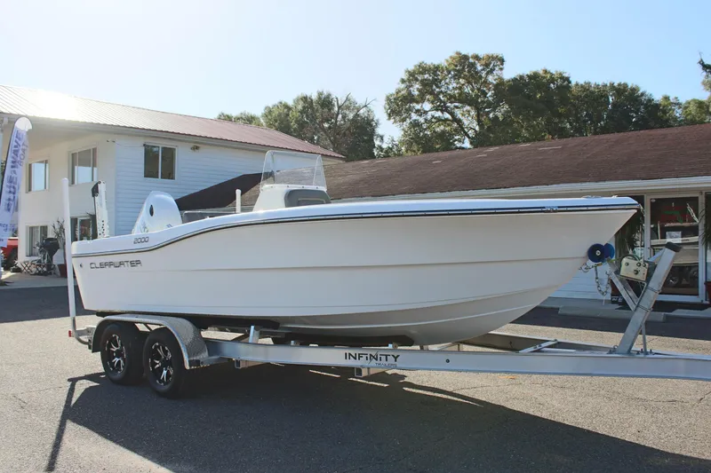 Slide: The Image of 2024 Clear Water 2000 CC boat on trailer, parked outside a building. - 4
