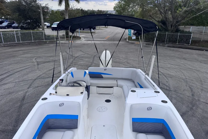 Slide: The Image of 2018 Hurricane SunDeck Sport 188 OB boat with seating and canopy in a parking area. - 14