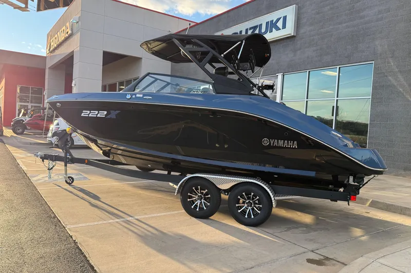 Slide: The Image of 2026 Yamaha Boats 222XD on trailer, sleek black design, parked outdoors. - 6