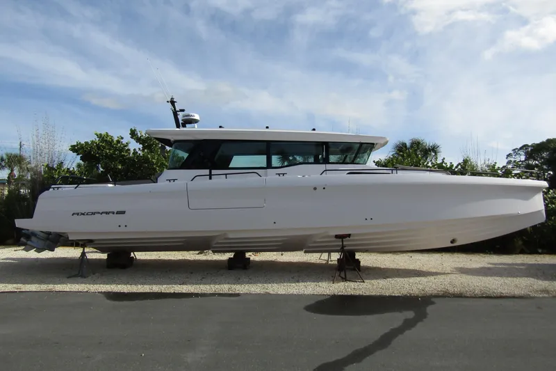 The Image of 2024 Axopar 45 XC Cross Cabin BRABUS Trim boat on display outdoors. - 0