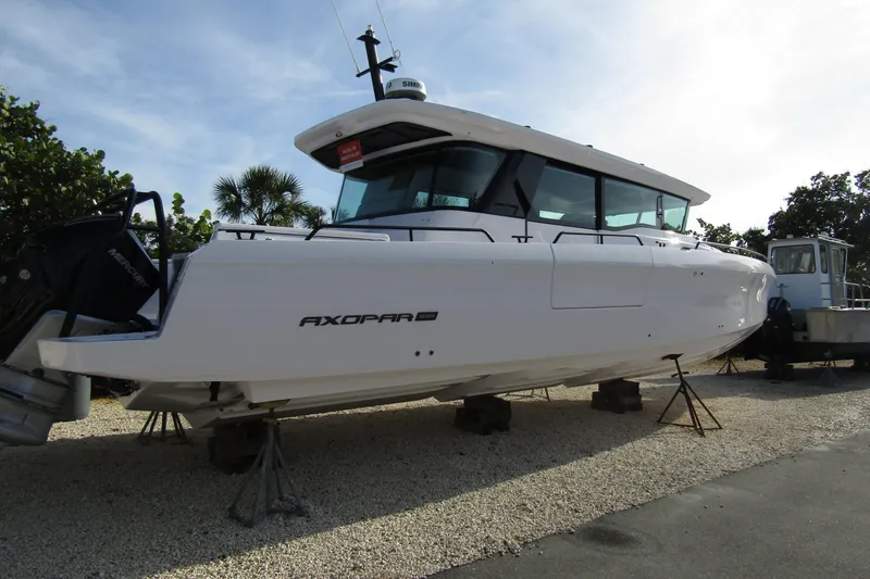 Slide: The Image of 2024 Axopar 45 XC Cross Cabin BRABUS Trim boat on display outdoors. - 2