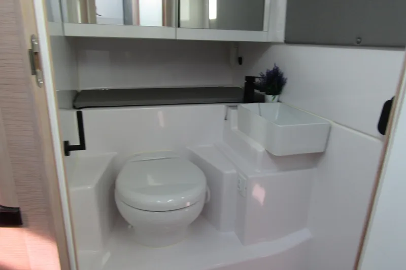 Slide: The Image of 2024 Axopar 45 XC Cross Cabin BRABUS Trim bathroom interior with toilet and sink. - 25