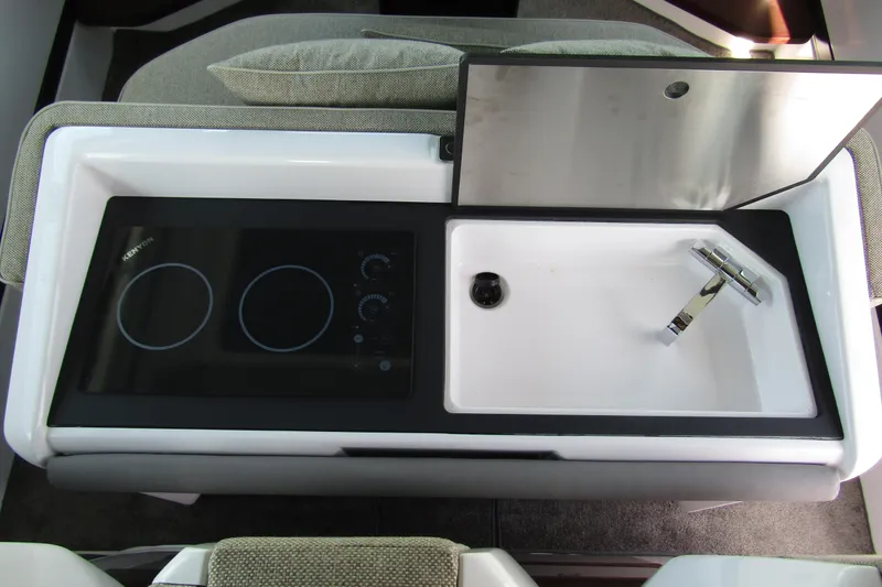 Slide: The Image of 2024 Axopar 45 XC Cross Cabin BRABUS Trim kitchen area with stove and sink. - 31