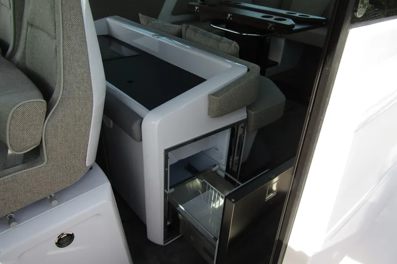 Slide: The Image of 2024 Axopar 45 XC Cross Cabin BRABUS interior with open mini fridge and seating. - 35