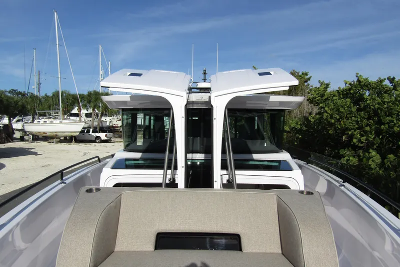 Slide: The Image of 2024 Axopar 45 XC Cross Cabin BRABUS Trim with open roof, docked near sailboats. - 8