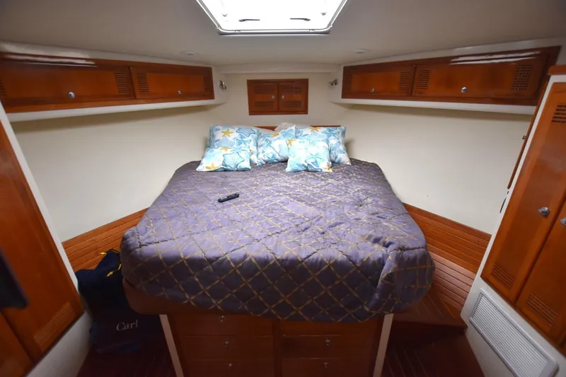 Slide: The Image of Cozy cabin interior of 1998 Cabo 45 Express with wooden cabinets and a comfortable bed. - 10