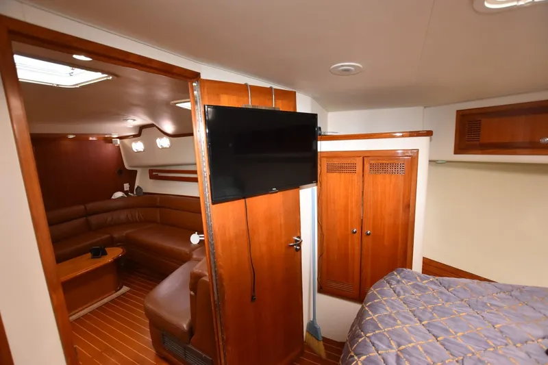 Slide: The Image of Interior of 1998 Cabo 45 Express yacht with wood paneling and cozy seating area. - 11