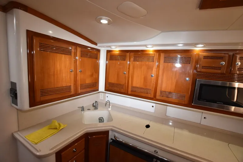 Slide: The Image of 1998 Cabo 45 Express yacht kitchen with wooden cabinets and modern appliances. - 15