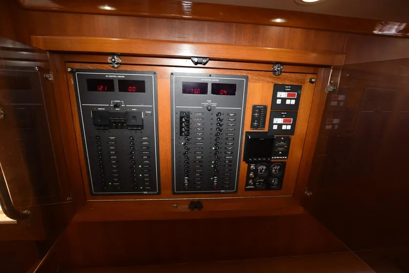 Slide: The Image of Electrical control panel on a 1998 Cabo 45 Express boat, featuring various switches and gauges. - 24