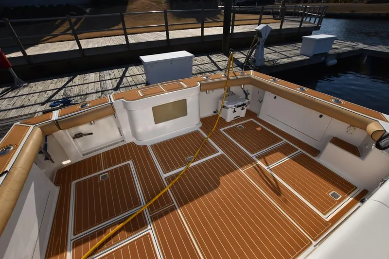 Slide: The Image of Spacious deck of 1998 Cabo 45 Express boat with teak flooring and dockside view. - 3