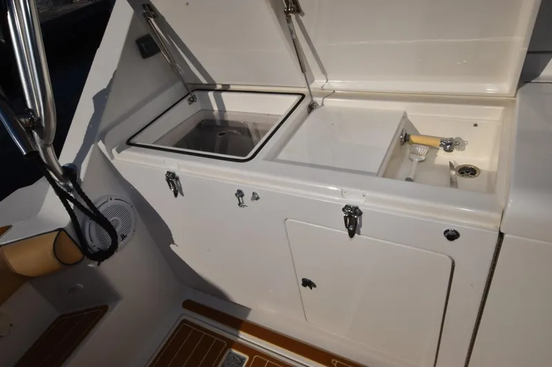 Slide: The Image of 1998 Cabo 45 Express boat interior with open storage compartments and cleaning tools. - 4