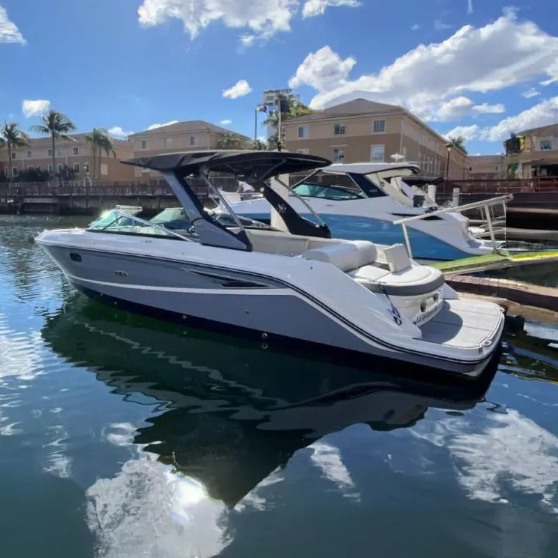 The Image of 2021 Sea Ray SLX 280 boat docked in a marina with palm trees in the background. - 0