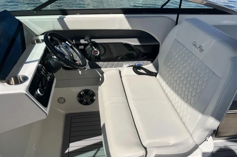 Slide: The Image of 2021 Sea Ray SLX 280 boat interior with steering wheel and white seating. - 12