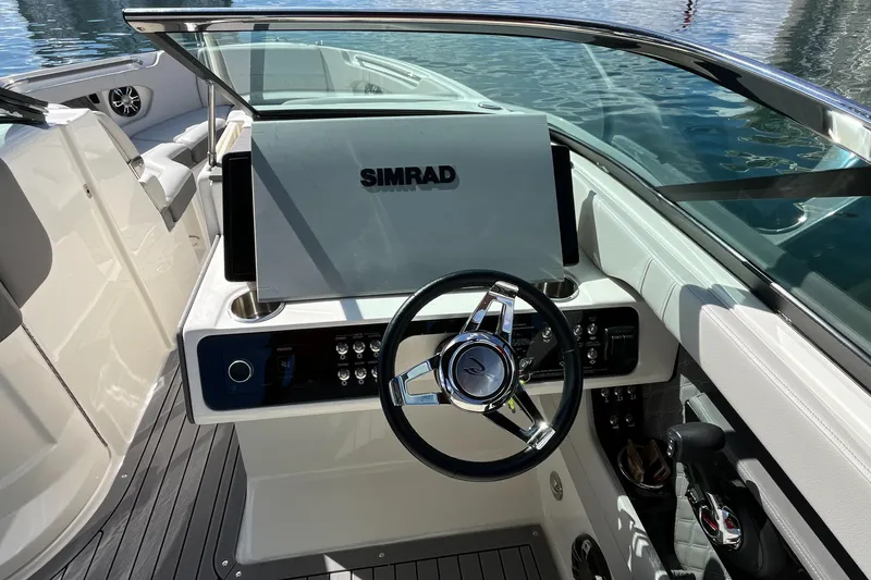 Slide: The Image of 2021 Sea Ray SLX 280 boat helm with Simrad display and sleek steering wheel. - 13