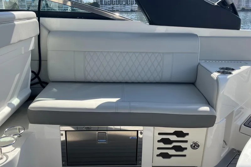 Slide: The Image of 2021 Sea Ray SLX 280 boat interior with cushioned seating and storage compartment. - 27