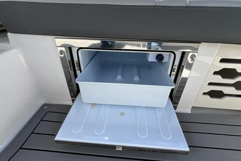 Slide: The Image of 2021 Sea Ray SLX 280 boat storage compartment with open drawer on deck. - 28