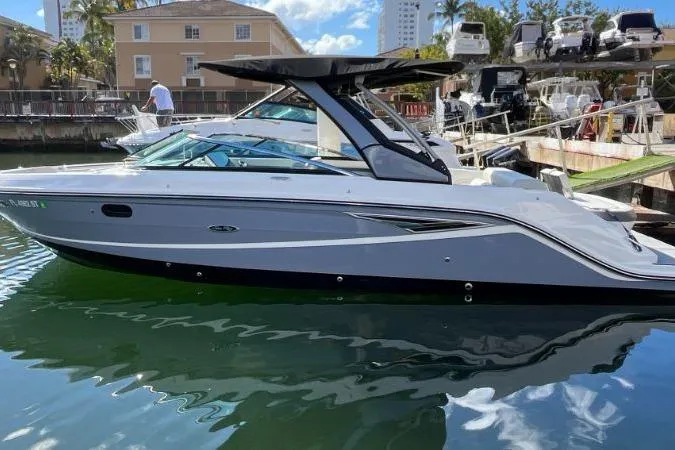 Slide: The Image of 2021 Sea Ray SLX 280 boat docked in a marina under clear skies. - 3